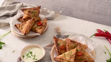 Hint samosaları - kızarmış ya da fırında hamur tatlısı ve baharatlı mutfak tezgahında areca yaprağı tabağında servis edilen lezzetli Hint yemekleri..