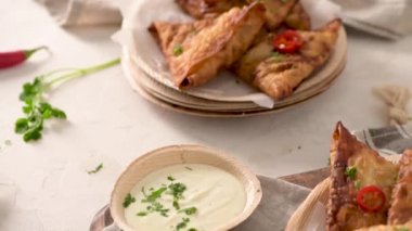 Hint samosaları - kızarmış ya da fırında hamur tatlısı ve baharatlı mutfak tezgahında areca yaprağı tabağında servis edilen lezzetli Hint yemekleri..