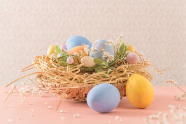 Pembe arka planda yuvada paskalya yumurtaları.
