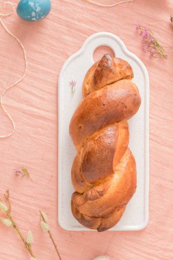 Portekiz geleneksel paskalya pastası. Paskalya masasında yumurtalı folar. Çiçekler ve renkli boyanmış yumurtalar.