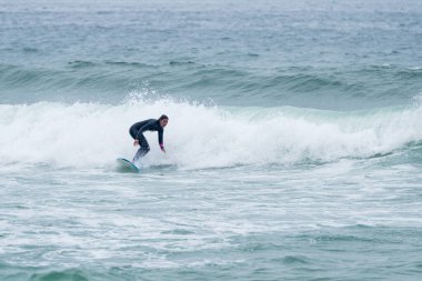 Sörfçü kız Furadouro sahilinde yumuşak bir sörf tahtası ile sörf yapıyor, Ovar - Portekiz.