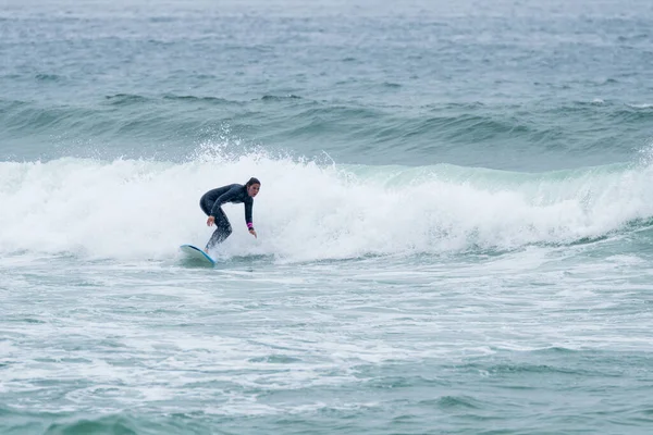 Sörfçü kız Furadouro sahilinde yumuşak bir sörf tahtası ile sörf yapıyor, Ovar - Portekiz.