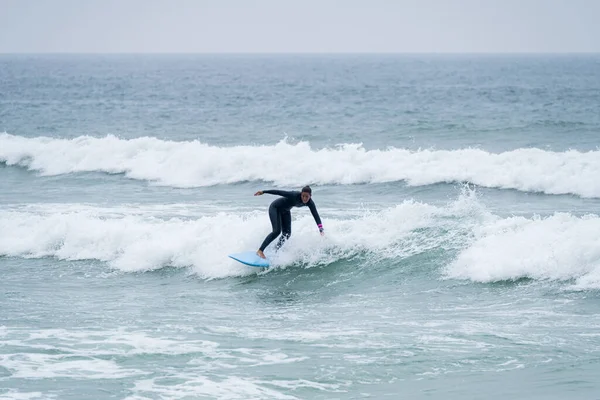 Sörfçü kız Furadouro sahilinde yumuşak bir sörf tahtası ile sörf yapıyor, Ovar - Portekiz.