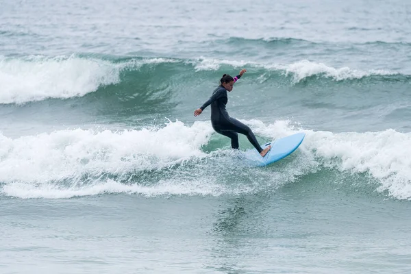 Sörfçü kız Furadouro sahilinde yumuşak bir sörf tahtası ile sörf yapıyor, Ovar - Portekiz.
