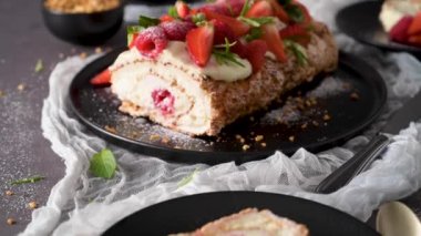 Meringue roll cake with cream, raspberries. Roulade, summer dessert served in ceramic plate.