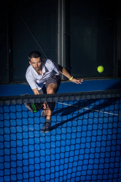 スポーツヨーロッパ人男性で白いTシャツ遊びパデルテニス室 — ストック写真