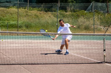 Tenisçi sahada bir düşüş atışı yapıyor..