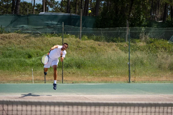 Tenisçi kortta hizmet veriyor.