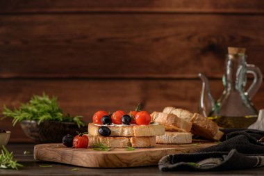 Krem peynirli taze bruschetta, siyah zeytin ve vişneli domates yakından..