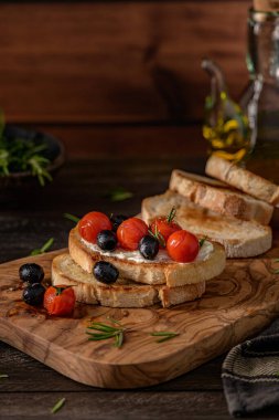 Krem peynirli taze bruschetta, siyah zeytin ve vişneli domates yakından..
