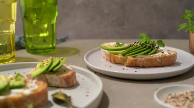 Avokado krem peynirli sağlıklı tost ve tabakta buğday ekmeği. Lezzetli atıştırmalıklar ve avokado sandviçleri. Yemek kompozisyonu, lezzetli İtalyan yemeği..