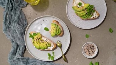 Healthy toast with avocado cream cheese and wheat bread on a plate. Delicious snacks and avocado sandwiches. Food composition, tasty Italian meal.