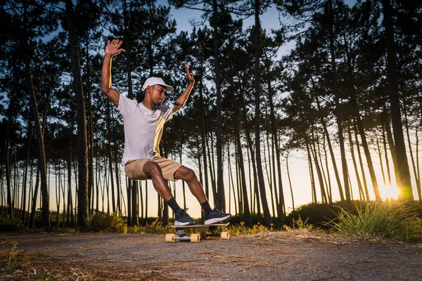 Surf skater performing a slide by the pine forest at sunset in Maceda, Ovar - Portugal.