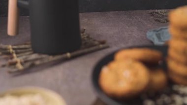 Homemade oatmeal raisin cookies with cup of cappuccino on rustic background.