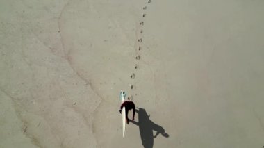 Kumlu sahilde yürüyen sörfçünün hava görüntüsü Murtosa, Aveiro - Portekiz.