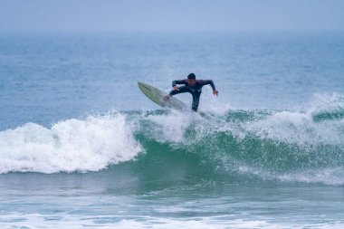 Brezilyalı sörfçü Portekiz 'in Atlantik kıyılarında hareket halinde. Furadouro plajında bulutlu bir sabah, Ovar - Portekiz.