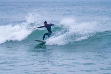 Brezilyalı sörfçü Portekiz 'in Atlantik kıyılarında hareket halinde. Furadouro plajında bulutlu bir sabah, Ovar - Portekiz.