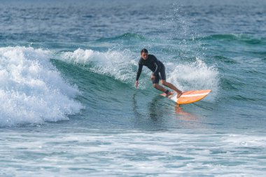 Sörfçü gün batımında iş başında. Furadouro plajı, Ovar - Portekiz.