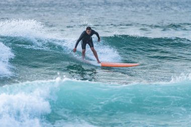 Sörfçü gün batımında iş başında. Furadouro plajı, Ovar - Portekiz.