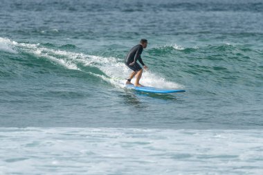 Sörfçü gün batımında iş başında. Furadouro plajı, Ovar - Portekiz.