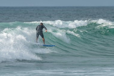 Sörfçü gün batımında iş başında. Furadouro plajı, Ovar - Portekiz.