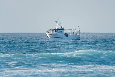 Portekiz Atlantik kıyısında küçük bir balıkçı teknesi. Gıda endüstrisi, geleneksel zanaat, çevresel hasar kavramları.