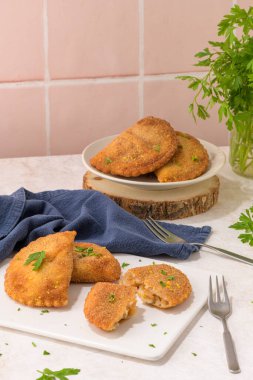 Et köfteleri ve maydanoz yaprakları mutfak tezgahındaki beyaz seramik tabaklarda..