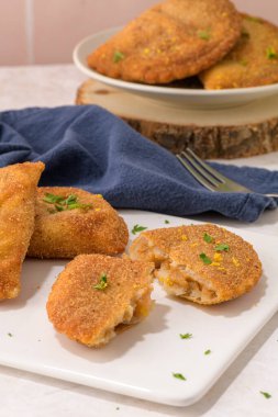 Et köfteleri ve maydanoz yaprakları mutfak tezgahındaki beyaz seramik tabaklarda..