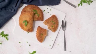 Et köfteleri ve maydanoz yaprakları mutfak tezgahındaki beyaz seramik tabaklarda..