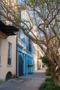 Charleston, South Carolina, USA - March 18, 2022:  Street scene in the historic southern city of Charleston South Carolina with landmark Rainbow Row colorful homes in view. 