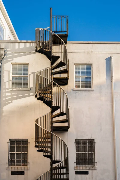 Building exterior with windows and wrought iron spiral staircase