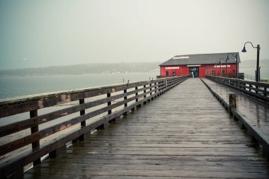 Coupeville Washington 'dan Whidbey Adası' ndaki rıhtım ve tarihi bina manzaralı yağmurlu bir günde