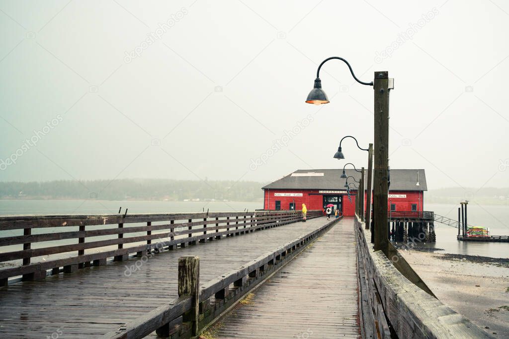 View from Coupeville Washington on Whidbey Island with pier and historic building in view, on a rainy day