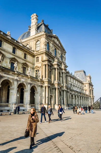 Turistas caminan en el fondo del Louvre — Foto de Stock