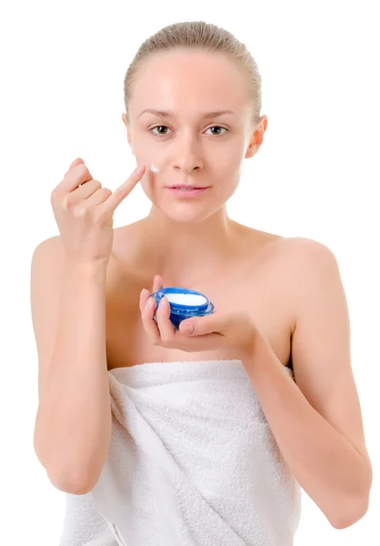 Vrouw die crème op haar gezicht aanbrengt — Stockfoto