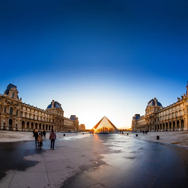 Sunset shines through the glass pyramid of the Louvre museum — Stock Photo, Image