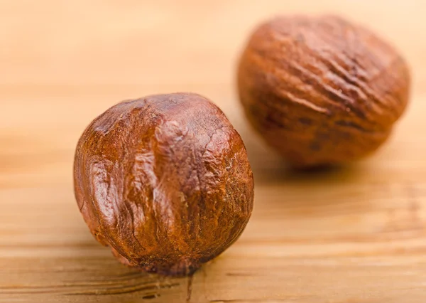 A pile of shell-less hazelnuts, isolated on textural wood backgr — Stock Photo, Image