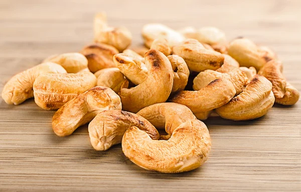 A handful of roasted cashew nuts on wood background — Stock Photo, Image