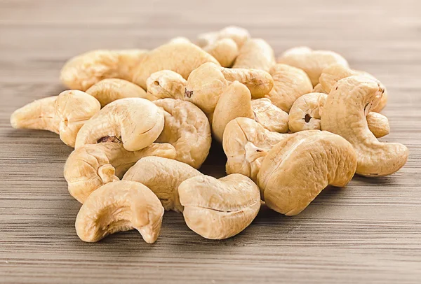 A handful of row cashew nuts on wood background — Stock Photo, Image