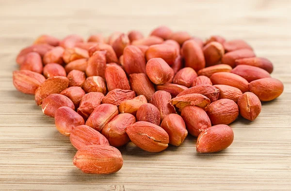 Heap of roasted peanuts on the wooden background — Stock Photo, Image