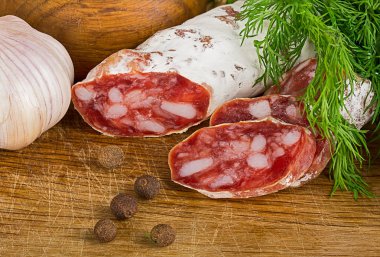 dereotu ve biber ile kesme tahtası üzerinde Salame dilimlenmiş