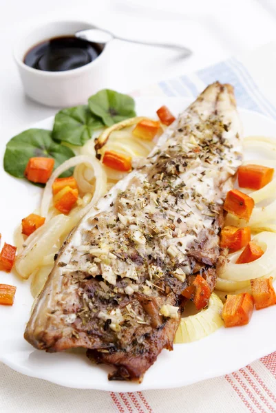 Le poisson cuit au four avec des carottes frites et l'oignon — Photo
