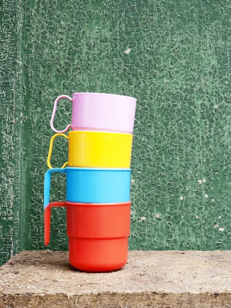 Colored cups on the abstract wooden background — Stock Photo, Image