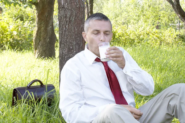 Geschäftsmann trinkt Milch — Stockfoto