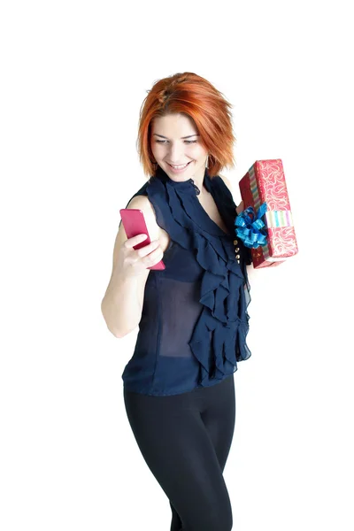 Chica feliz con un teléfono y un regalo sobre un fondo blanco —  Fotos de Stock