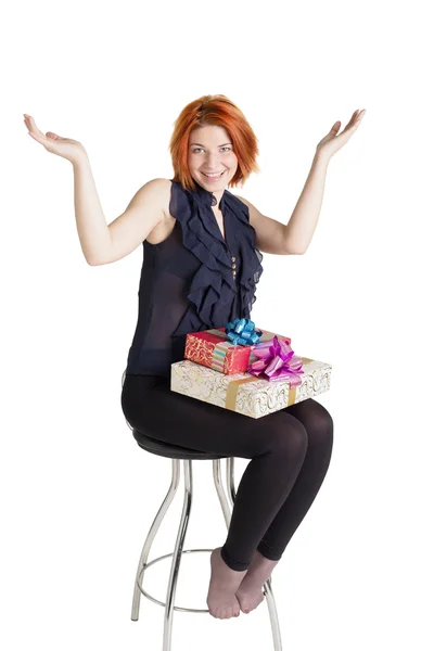 Fröhliches Mädchen auf einem Stuhl mit Schachteln gifts.holiday Neujahr und Weihnachten — Stockfoto