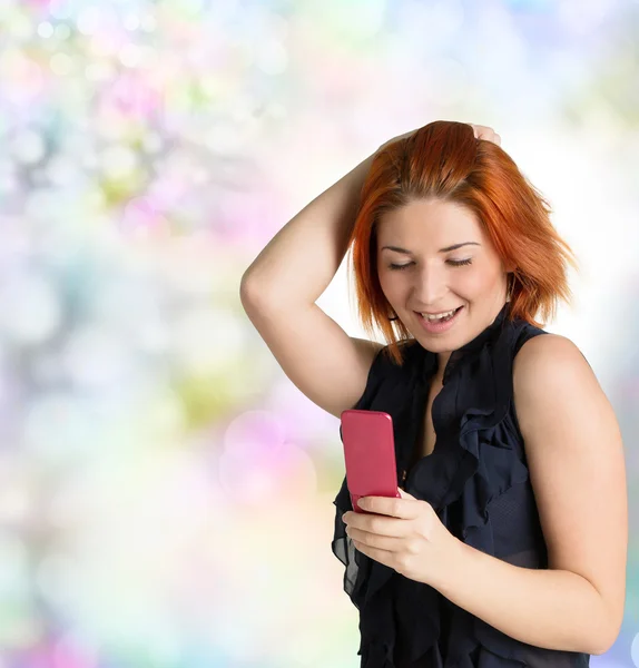 Emotionele gelukkig vrouw met rood haar en een telefoon op de abstracte feestelijke achtergrond — Stockfoto