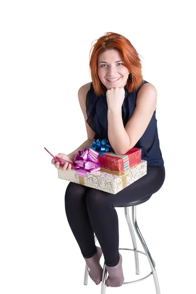 Mujer pelirroja feliz con una caja de regalo y un teléfono en el fondo blanco — Foto de Stock