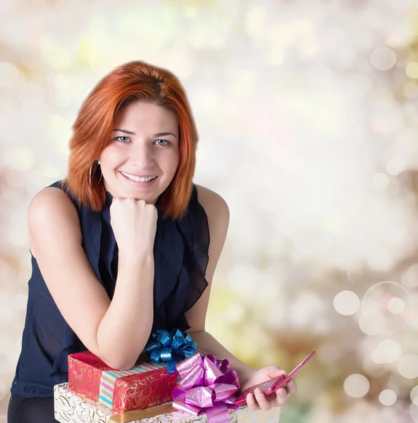 Glada leende rödhårig kvinna med lådor gåvor och phone.christmas — Stockfoto