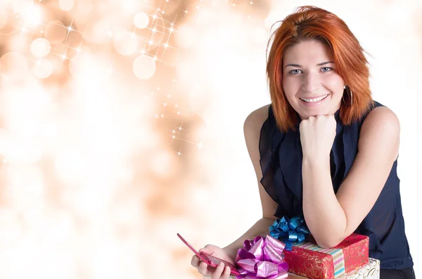 Feliz sorrindo mulher ruiva com caixas presentes e telefone — Fotografia de Stock